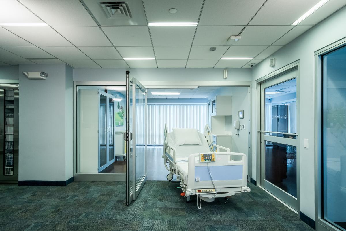 A hospital bed going through the procare doors.