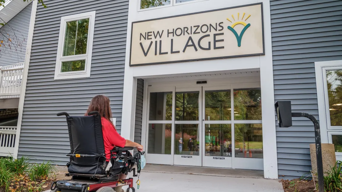 woman in a wheelchair entering building with automatic sliding door. 