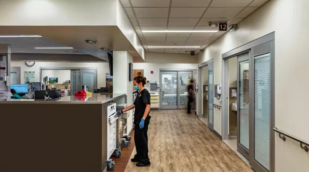 A healthcare worker standing by a desk.  Photo Credit: MKM Build Photography www.mkmbuild.com.jpg