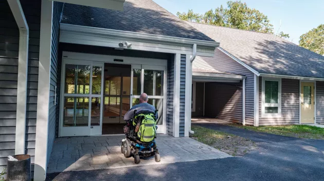 A person in a wheelchair going through a door.