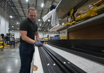 man assembling an automatic door in factory