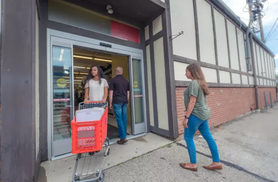 shoppers walking in and out of storefront