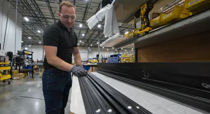 man assembling an automatic door in factory