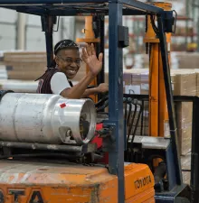 woman waving driving forklift