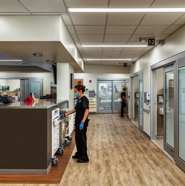 A healthcare worker standing by a desk.  Photo Credit: MKM Build Photography www.mkmbuild.com.jpg