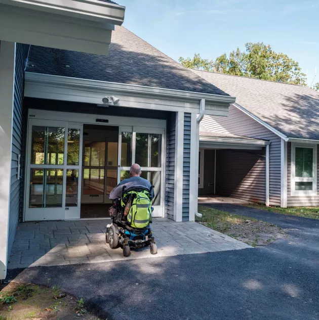 NHV wheelchair front door.jpg A person in a wheelchair going through a door.