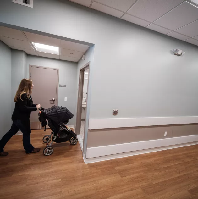 SAT New Horizons Village-door-stroller.jpg A person walking through a door with a stroller.