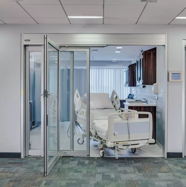 A set of telescoping hospital doors with a bed in the doorway.