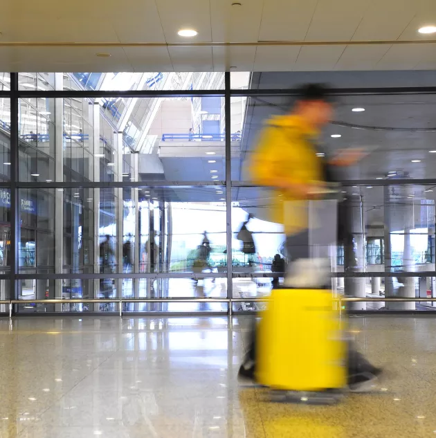 airport-subject-walking-suitcase-blur.jpg A person walking through a transit station.