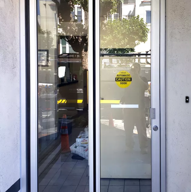 folding-2-panel-bifold-in-clear-anodized-finish.jpg A set of folding doors to a building.