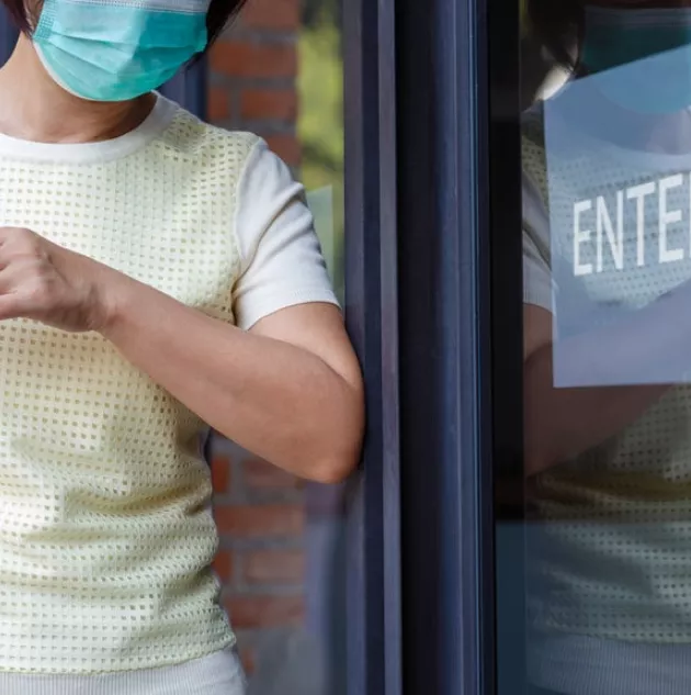 manual-door-handle-germs.jpeg A person using a touchless door.