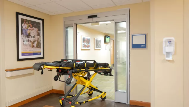 A set of hospital doors with a gurney moving through.