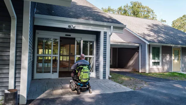 A person in a wheelchair going through a door.