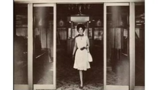 history_slidingDoor.jpeg A woman walking through a sliding door.