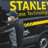 A person closing a van door; on the van it says Stanley Access Technologies.