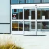 a woman walking towards a set of doors.